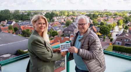 Op de foto neemt wijkraadvoorzitter Jolanda van der Nagel het jubileummapje in ontvangst uit handen van Henk Imthorn, voorzitter van de Vereniging Oud Valkenburg.